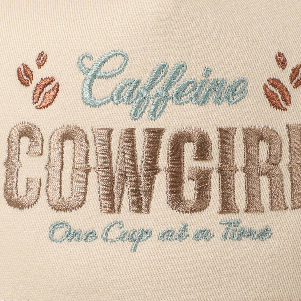 Embroidered cap with 'Caffeine Cowgirl One Cup at a Time' text and coffee bean designs on beige background