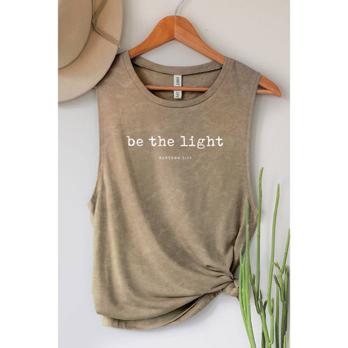 Brown tank top with 'be the light' text on a hanger against a neutral background