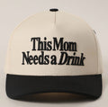 Beige and black cap with 'This Mom Needs a Drink' text on a light gray background