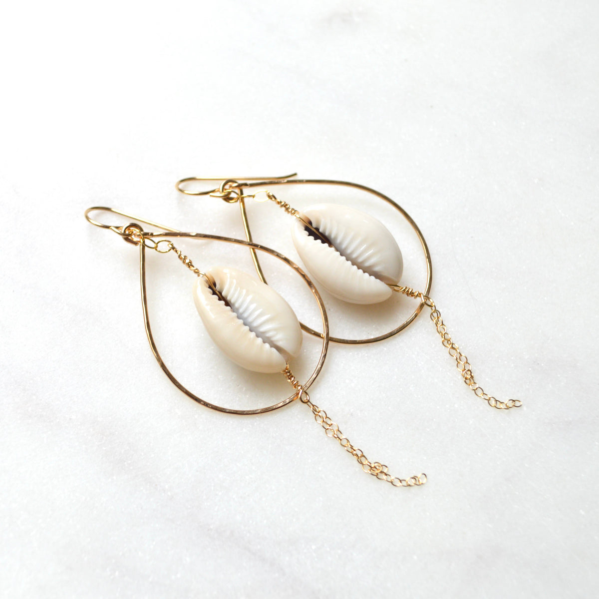 Shell earrings with gold loops on a white background