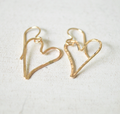 Gold heart-shaped earrings on a light background