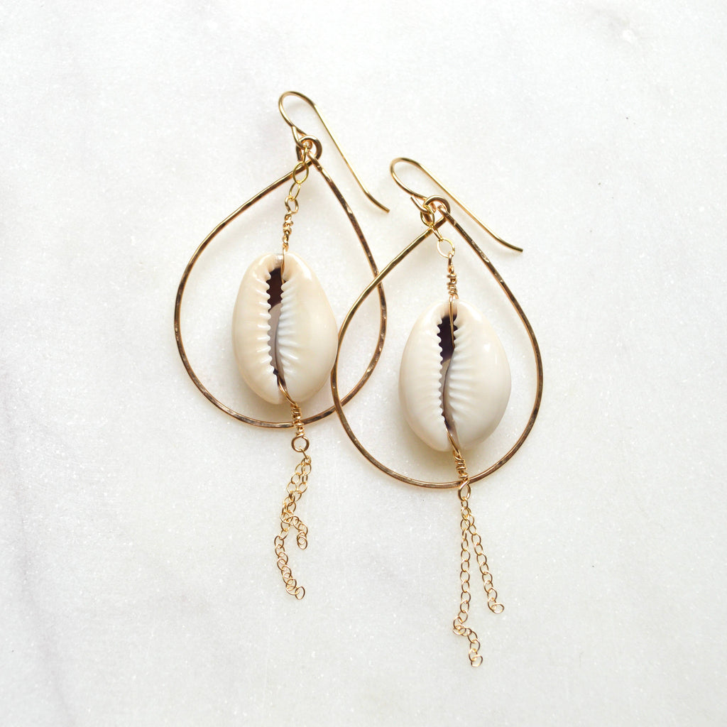 Shell earrings with gold loops and chains on a white background