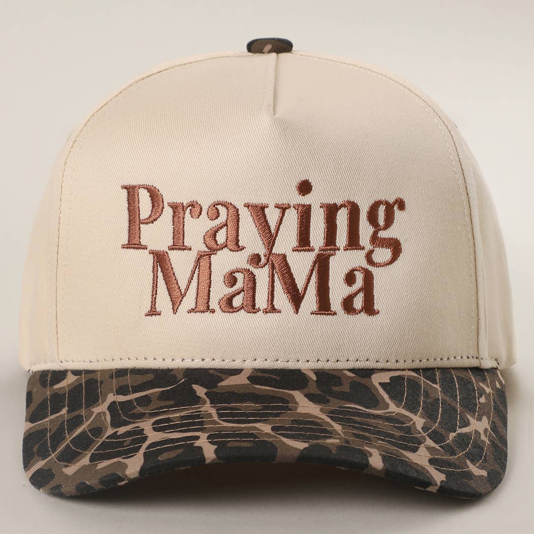 Beige cap with 'Praying MaMa' text and camouflage pattern on a light gray background