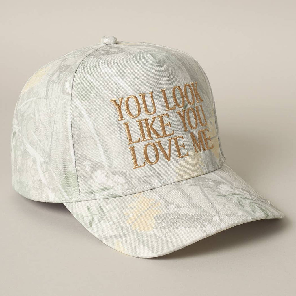 Cap with 'You Look Like You Love Me' text on a beige background
