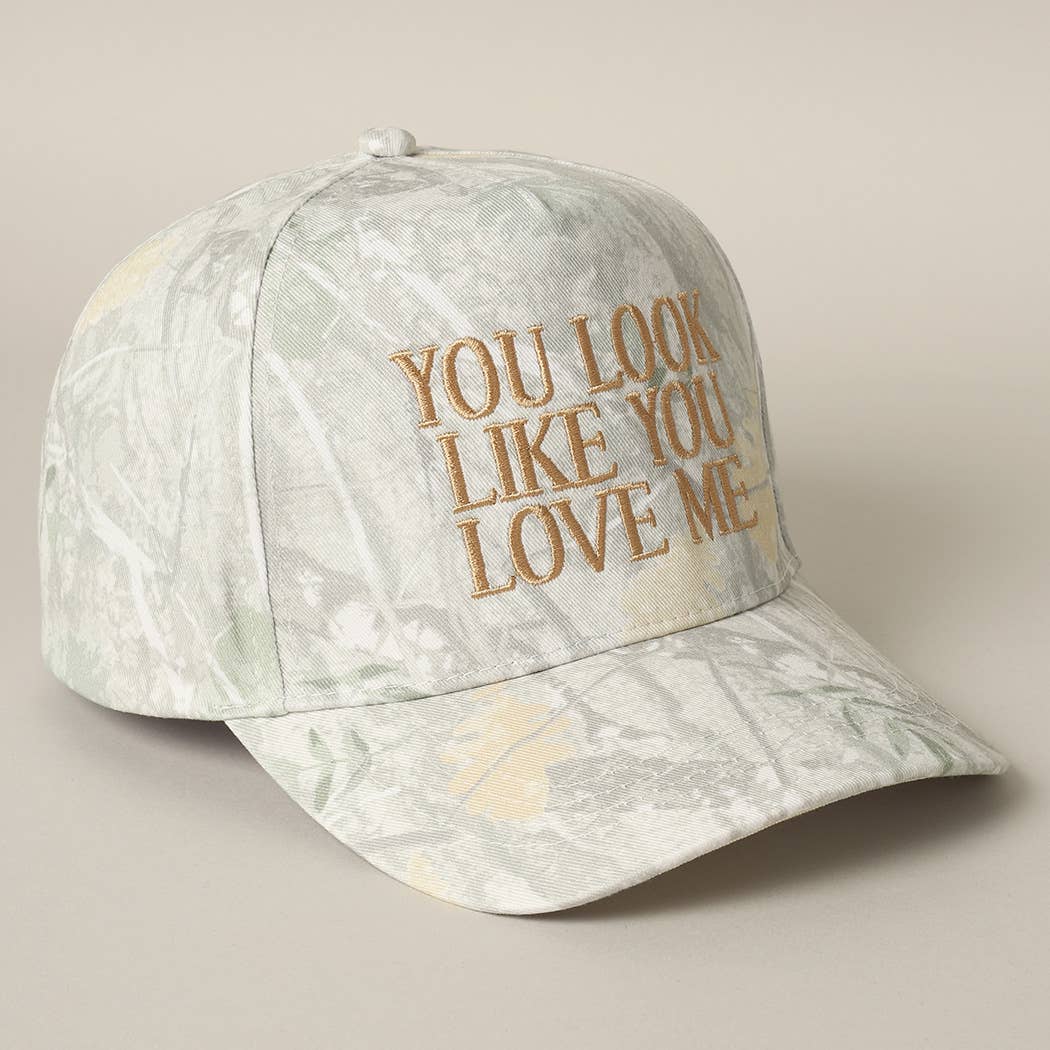 Cap with 'You Look Like You Love Me' text on a beige background