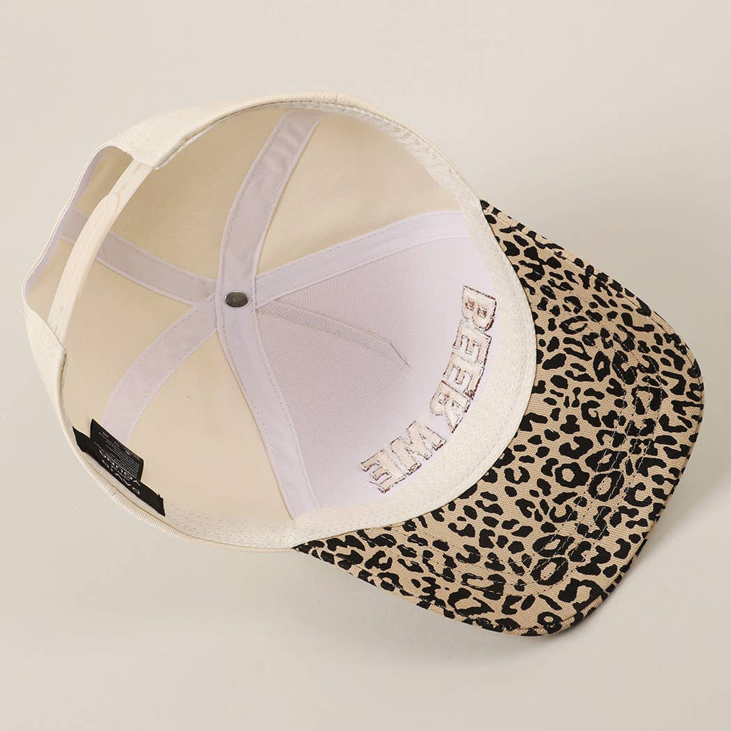 Cap with leopard print visor on a beige background